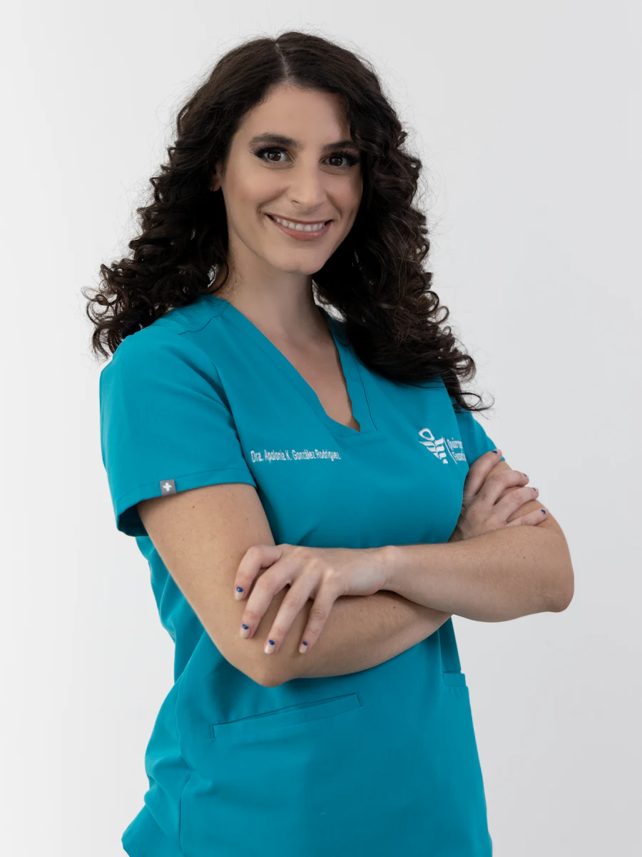 A nurse in teal scrubs with arms crossed
